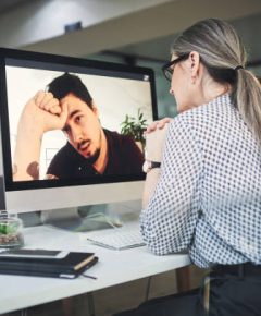 Shot of a mature psychologist conducting an online therapy session with her patient